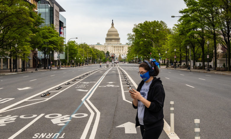 Une jeune femme masquée passant devant le capitole des Etats-Unis, à Washington DC.