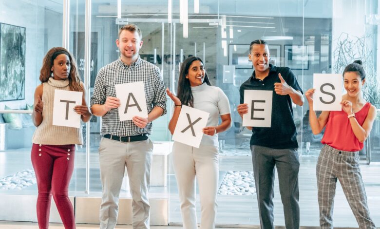 a group of people holding papers with printed taxes
