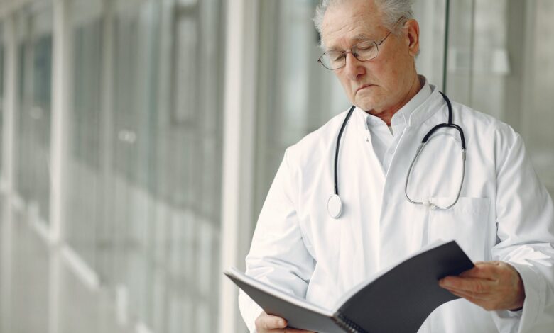 contemplative doctor in uniform reading clinical records