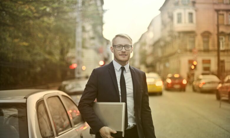 determined smiling businessman with laptop on street