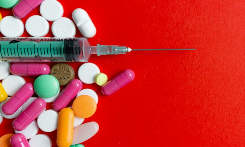 close up shot of pills and a syringe
